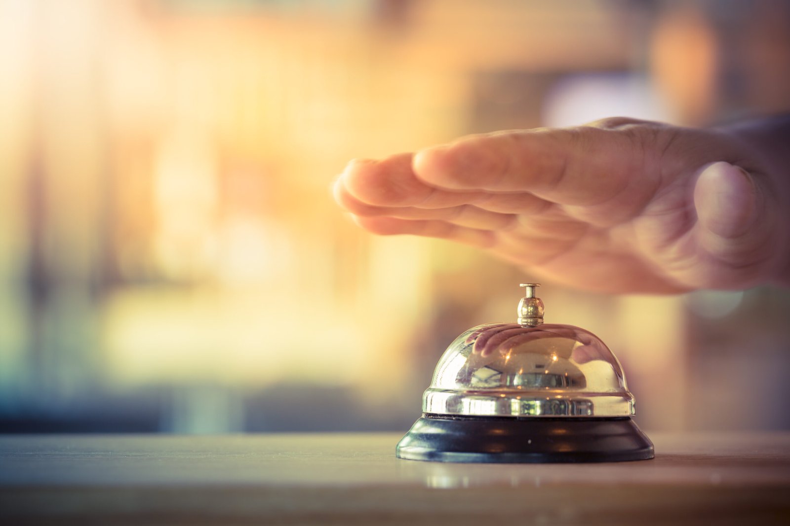 hand hovering over till bell symbolising hospitality