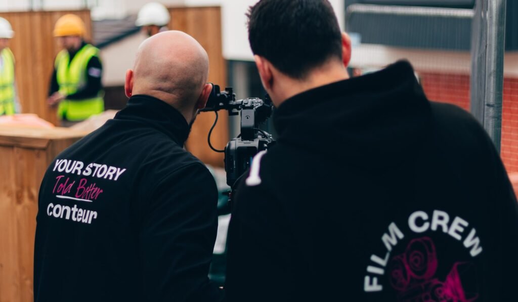 Simon and Tom, Conteur camera operators, are on set at a video production shoot. They are filming a construction site