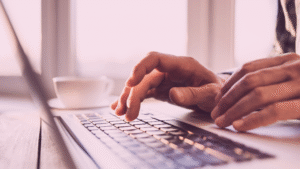 A close-up image of an individual's hand, typing on a keyboard.